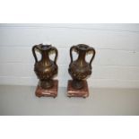 PAIR OF CONTINENTAL BRONZED METAL DOUBLE HANDLED VASES SET ON POLISHED MARBLE BASES