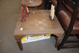 LARGE 20TH CENTURY CARVED CHESS TABLE TOGETHER WITH A SET OF ORIENTAL FIGURAL RESIN CHESS PIECES