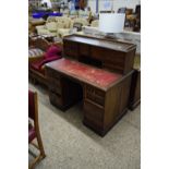 LATE VICTORIAN OAK DESK WITH EIGHT DRAWERS AND TWO DOORS OVER A TOOLED RED LEATHER WRITING SURFACE