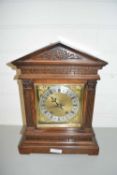 EARLY 20TH CENTURY MANTEL OR BRACKET CLOCK SET IN A HARDWOOD ARCHITECTURAL CASE