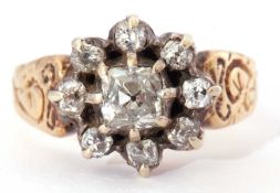 Diamond cluster ring centering an old cushion cut diamond surrounded by seven small old cut diamonds