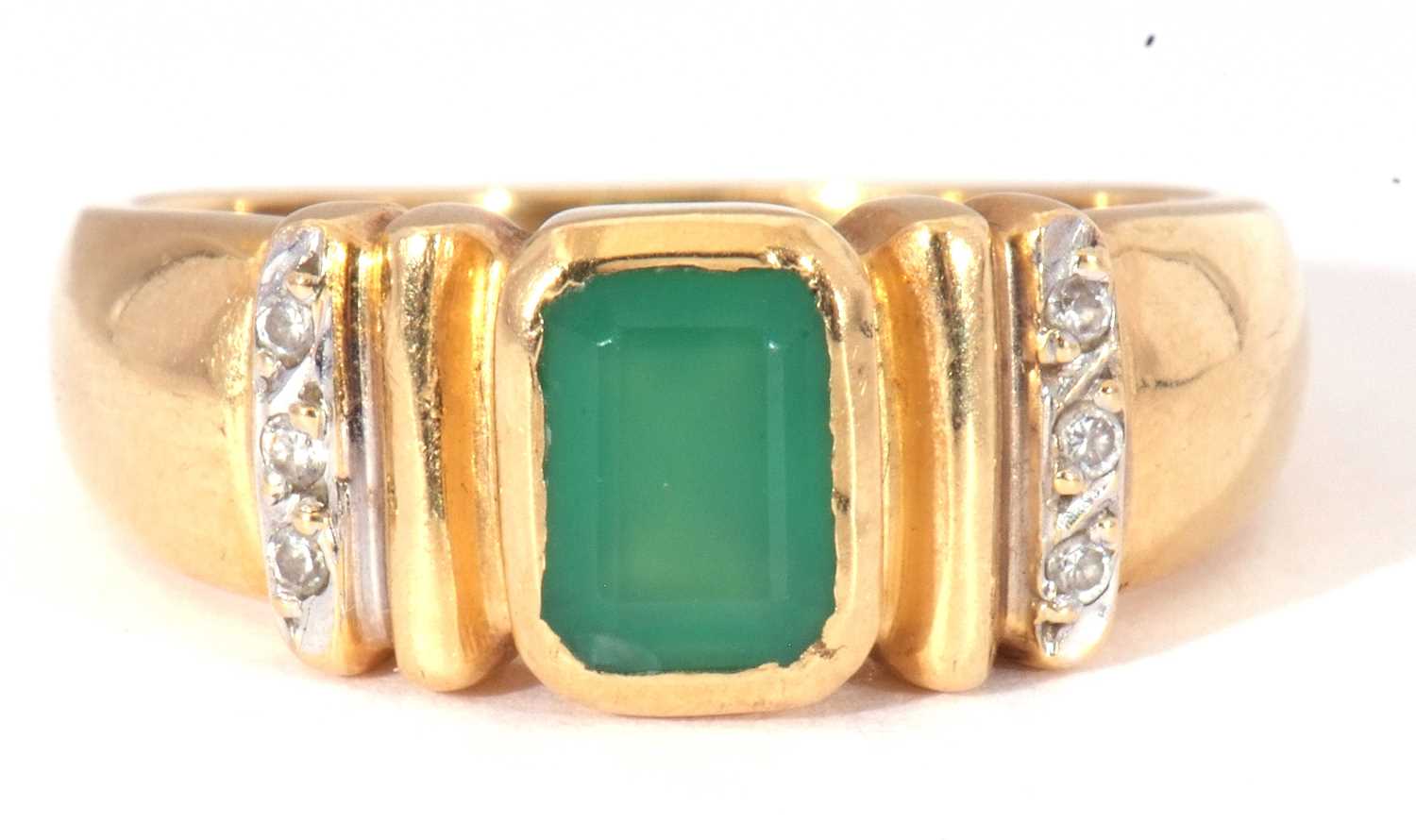 Modern green and white stone set ring featuring a central rectangular cut green stone in rub-over
