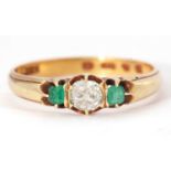 18ct gold diamond and emerald ring centering an old cut diamond, 0.25ct app, raised between two