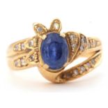 Sapphire and diamond designer ring, the oval shaped faceted sapphire four claw set between small