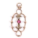 Open work pendant centering a small round ruby between seed pearl highlighted leaves (one