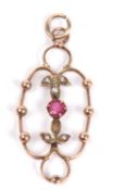 Open work pendant centering a small round ruby between seed pearl highlighted leaves (one