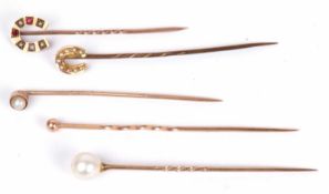 Five stick pins to include 9ct gold horseshoe example set with small seed pearls, a garnet and ruby,