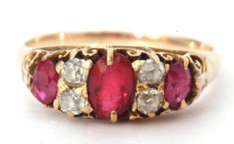 Yellow metal diamond and red stone ring featuring three graduated oval red stones highlighted