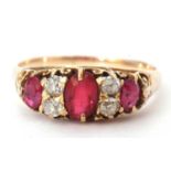 Yellow metal diamond and red stone ring featuring three graduated oval red stones highlighted