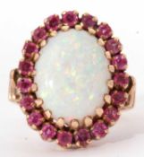 Large opal and ruby dress ring, the oval shaped cabochon opal 16x13 mm, multi claw set and raised