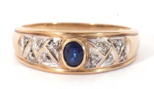 Modern 375 stamped ring centring a bezel set blue stone and highlighted with eight small single