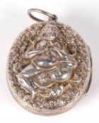 Large vintage Indian white metal locket of oval form, twin sided and embossed and chased with