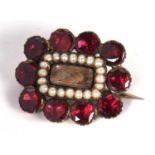 Antique mourning brooch the centre glazed panel with plaited hair framed within seed pearl surround,