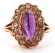 Amethyst and diamond cluster ring centering an oval cabochon cut amethyst, multiclaw set within a