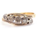 Five stone diamond ring featuring five small diamonds each in illusion settings between crossover