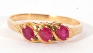 Modern three stone ruby ring featuring three faceted oval shaped rubies, size M