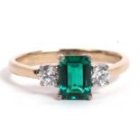 Green stone and diamond ring the central step cut green stone flanked by two brilliant cut