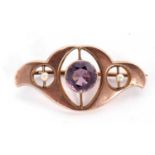 Amethyst and seed pearl set brooch in the art nouveau style centering a round faceted amethyst