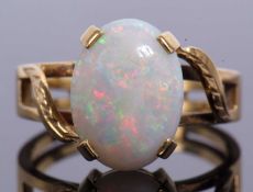 Large opalescent dress ring four claw set and raised between pieced, chased and engraved crossover