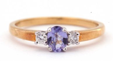 Tanzanite and diamond three stone ring, the oval cut tanzanite is 5x4mm raised between two small