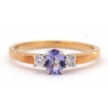 Tanzanite and diamond three stone ring, the oval cut tanzanite is 5x4mm raised between two small