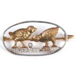 Precious metal diamond and pearl set bird brooch, the oval open work brooch with two birds