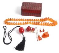 Mixed Lot: Vintage cherry amber large drum shaped bead on a black chord necklace, two loose