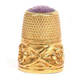 Antique 750 stamped thimble with a three leaf clover motif bottom band, the crown/cap with purple