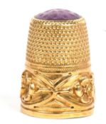 Antique 750 stamped thimble with a three leaf clover motif bottom band, the crown/cap with purple