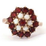 Garnet and opal cluster ring, a flower head design with thirteen small garnets and five small