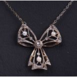 Diamond and seed pearl set bow pendant decorated with small graduated old cut diamonds and