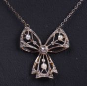 Diamond and seed pearl set bow pendant decorated with small graduated old cut diamonds and