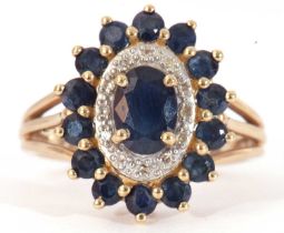 Modern 9ct gold sapphire and diamond cluster ring, the panel centres an oval cut sapphire within a