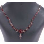 Vintage bohemian style garnet necklace, the curved bar bottom section with a floral cluster and