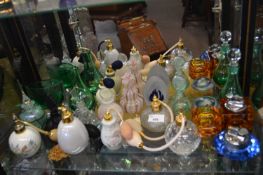 Quantity of perfume bottles and atomisers together with two glass table lighters one with matching