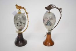 Pair of unusual painted glass egg shaped scenes with Chinese figures, the glass mounted on wooden