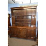 Early 20th Century oak dresser with shelved back over a base with two paneled doors and three