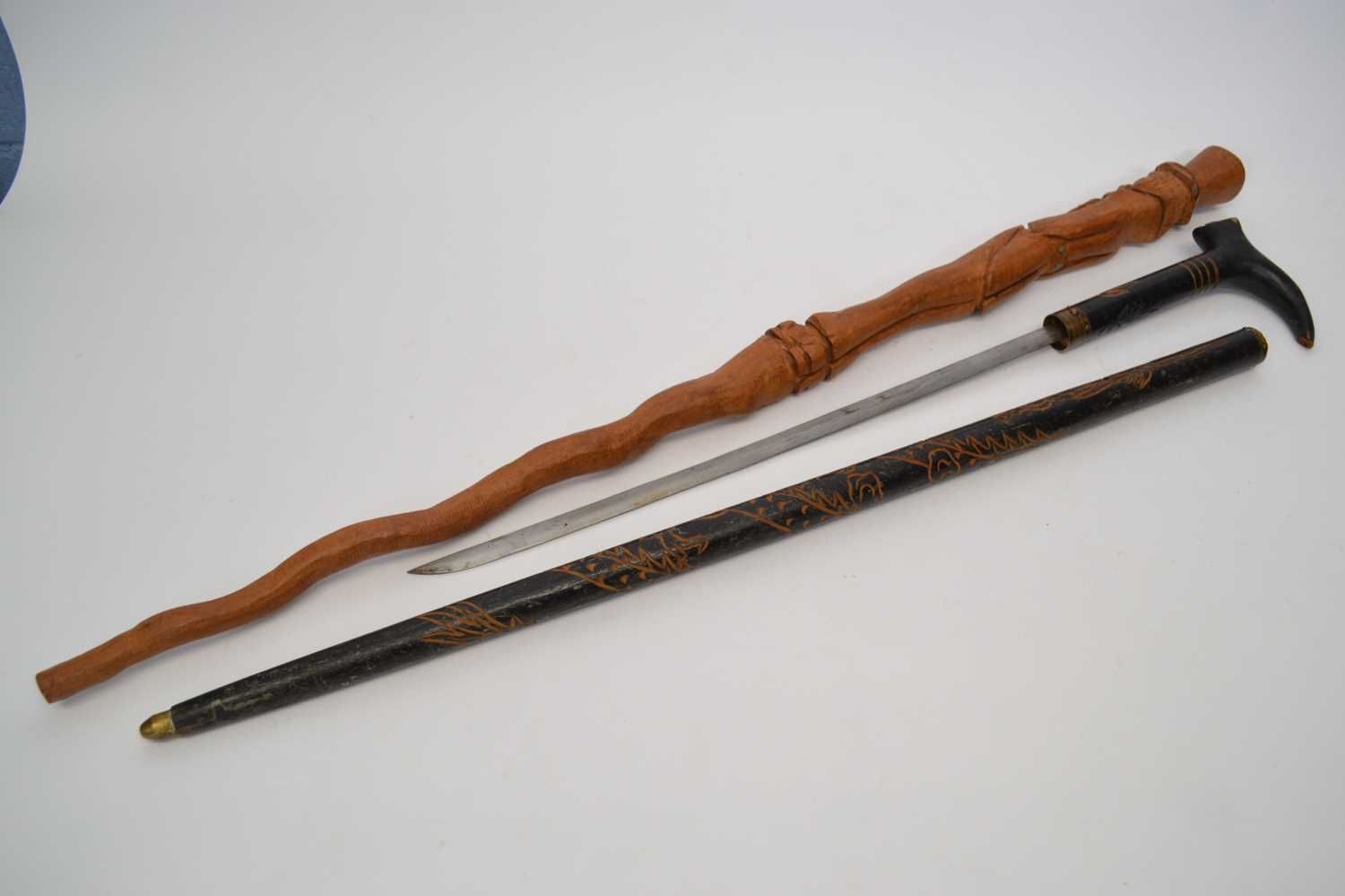Ebonised wooden sword stick with a carved design together with a further walking stick with a carved - Image 2 of 2