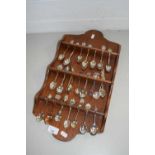 COLLECTION OF VARIOUS CRESTED COLLECTORS SPOONS ON WALL MOUNTED RACK