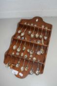 COLLECTION OF VARIOUS CRESTED COLLECTORS SPOONS ON WALL MOUNTED RACK