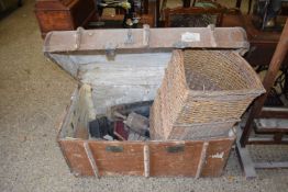 Vintage wooden bound trunk containing assorted items including books, leather boots, corner basket