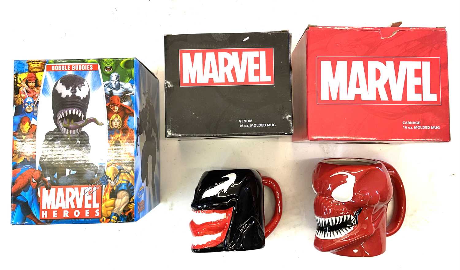 A mixed lot of boxed Marvel collectibles to include: - A Venom bobble-head - A Venom moulded mug - A