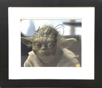 A framed and glazed 8x10 film still of Yoda from Star Wars, bearing the signature of Frank Oz in