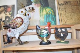 Two model chickens and a metal model of an owl