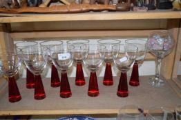 Set of modern red stemmed wine glasses and a further floral decorated over sized wine glass