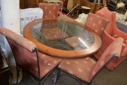 Metal framed glass topped circular dining table and four accompanying chairs