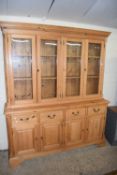 Modern pine kitchen dresser with four glazed doors over a base with four drawers and four doors,