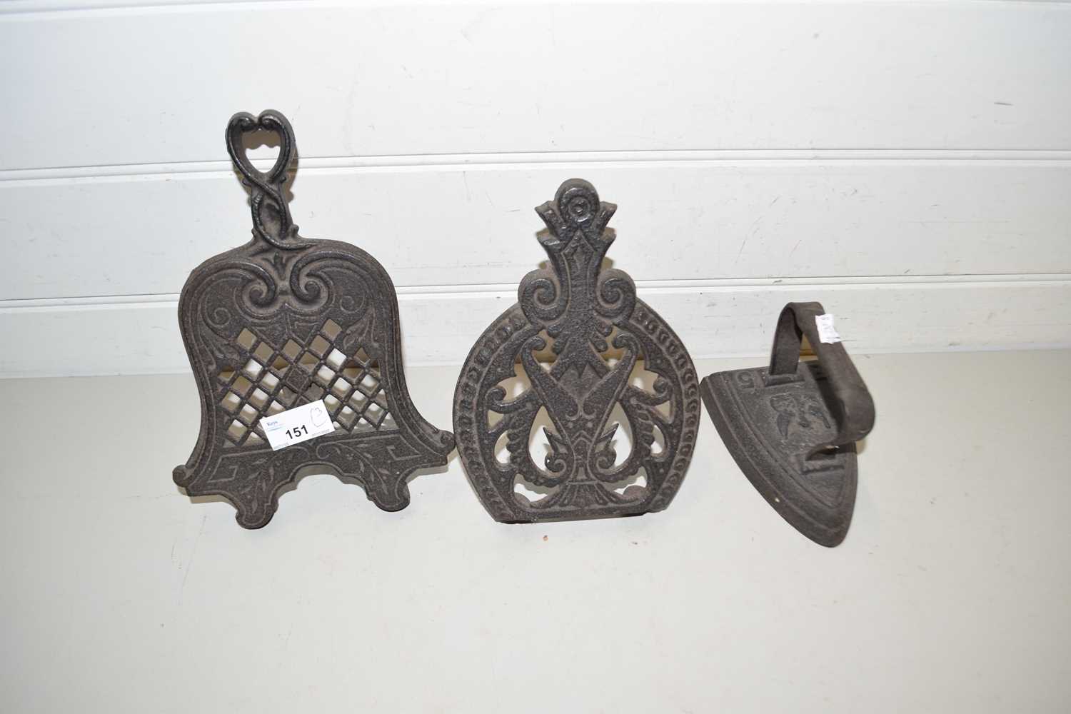 Two cast iron trivets and a flat iron