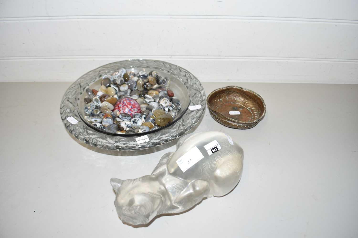 Heavy glass model of a cat together with a circular glass fruit bowl of polished pebbles