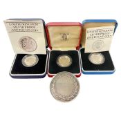 A mixed lot comprising three silver £1 proof coins and a Cambridge University medal.